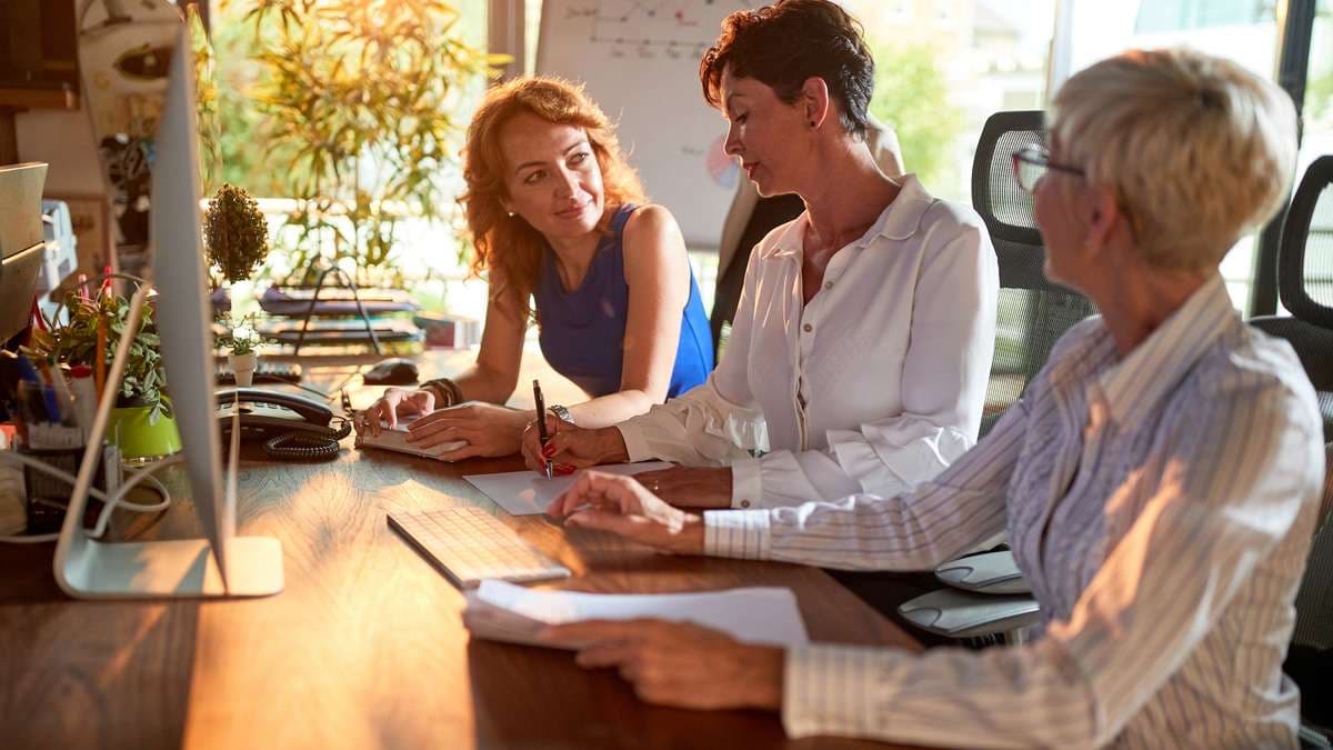Colleagues in discussion around an office desk