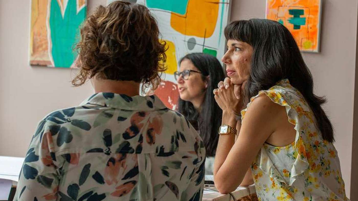 Teammates in conversation in an office hung with colorful art